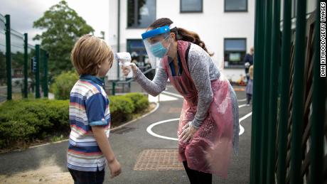 A school staff member takes a child&#39;s temperature at the Harris Academy&#39;s Shortlands school in London on June 4.