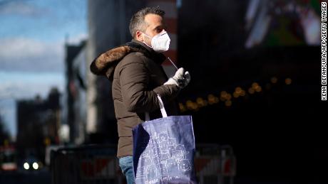 Wearing a mask in public helps protect the community from the spread of the coronavirus. A man wears a mask as he visits Times Square in New York December 10. 