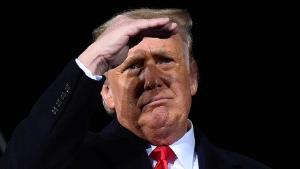 TOPSHOT - US President Donald Trump looks on during a rally in support of Republican incumbent senators Kelly Loeffler and David Perdue ahead of a Senate runoff in Dalton, Georgia on January 4, 2021. - President Donald Trump, still seeking ways to reverse his election defeat, and President-elect Joe Biden converge on Georgia on Monday for dueling rallies on the eve of runoff votes that will decide control of the US Senate. Trump, a day after the release of a bombshell recording in which he pressures Georgia officials to overturn his November 3 election loss in the southern state, is to hold a rally in the northwest city of Dalton in support of Republican incumbent senators Kelly Loeffler and David Perdue. (Photo by MANDEL NGAN / AFP) (Photo by MANDEL NGAN/AFP via Getty Images)