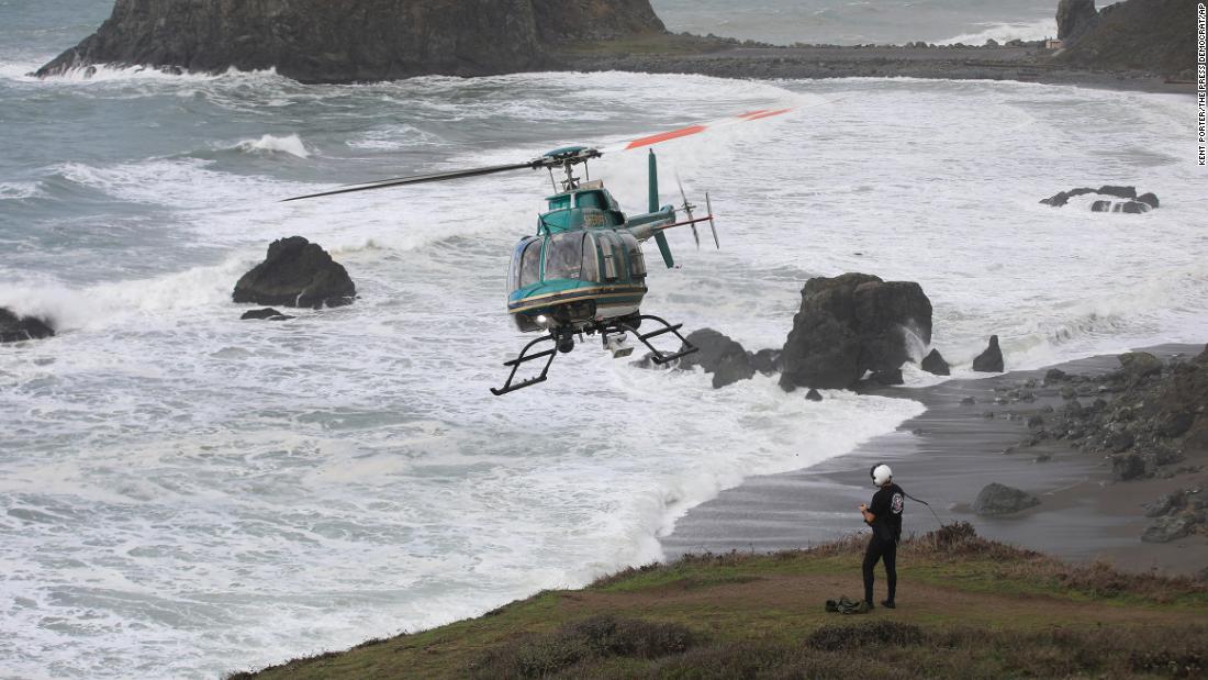 A father dies and his two young children are missing after they were swept away by a wave