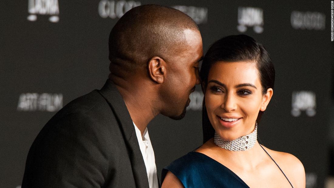 Kanye whispers to Kim on a red carpet in November 2014.