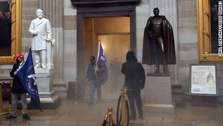 Supporters of US President Donald Trump enter the US Capitol&#39;s Rotunda as reported tear gas smoke fills a corridor on January 6, 2021, in Washington, DC. - Demonstrators breeched security and entered the Capitol as Congress debated the a 2020 presidential election Electoral Vote Certification. (Photo by Saul LOEB / AFP) (Photo by SAUL LOEB/AFP via Getty Images)