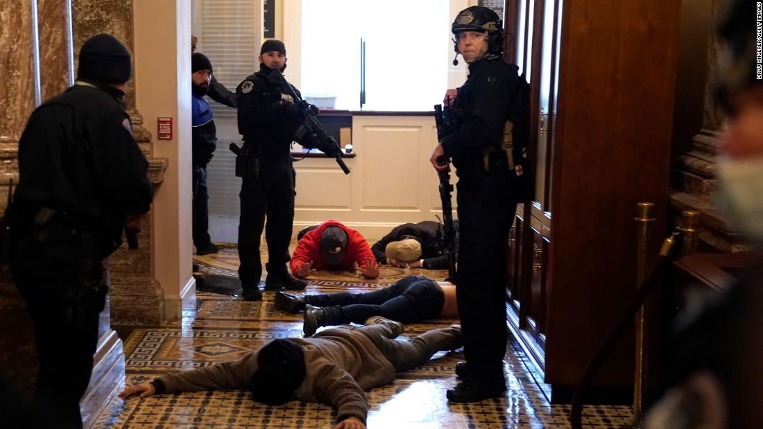 Capitol Police detain rioters outside of the House chamber.