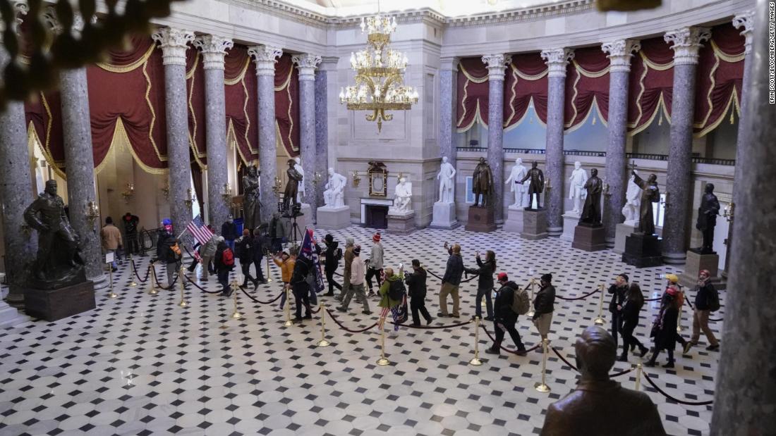 Trump supporters walk through the Capitol&#39;s Statuary Hall.