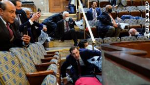 People shelter in the House gallery as protesters try to break into the House Chamber at the U.S. Capitol on Wednesday, Jan. 6, 2021, in Washington. (AP Photo/Andrew Harnik)