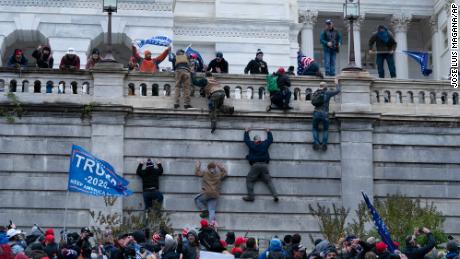 Supporters of President Donald Trump climb the west wall of the the U.S. Capitol on Wednesday, Jan. 6, 2021, in Washington.