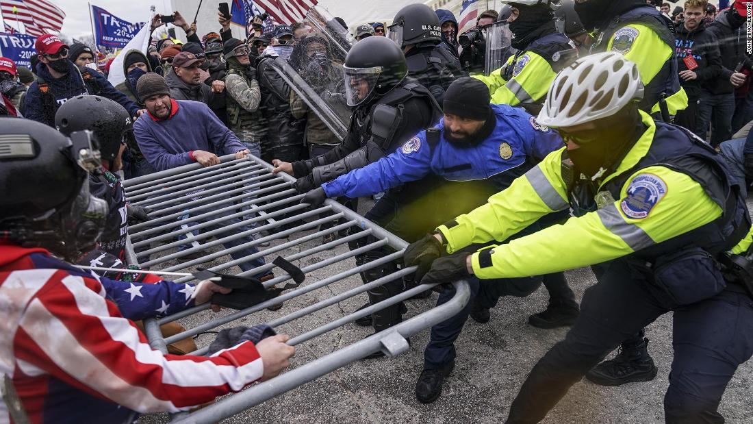 Trump supporters try to break through a police barrier.