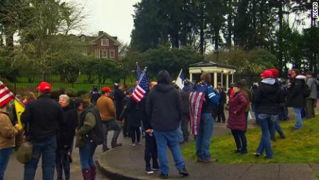 Demonstrators gather outside the gates of the Washington Governor&#39;s Mansion.