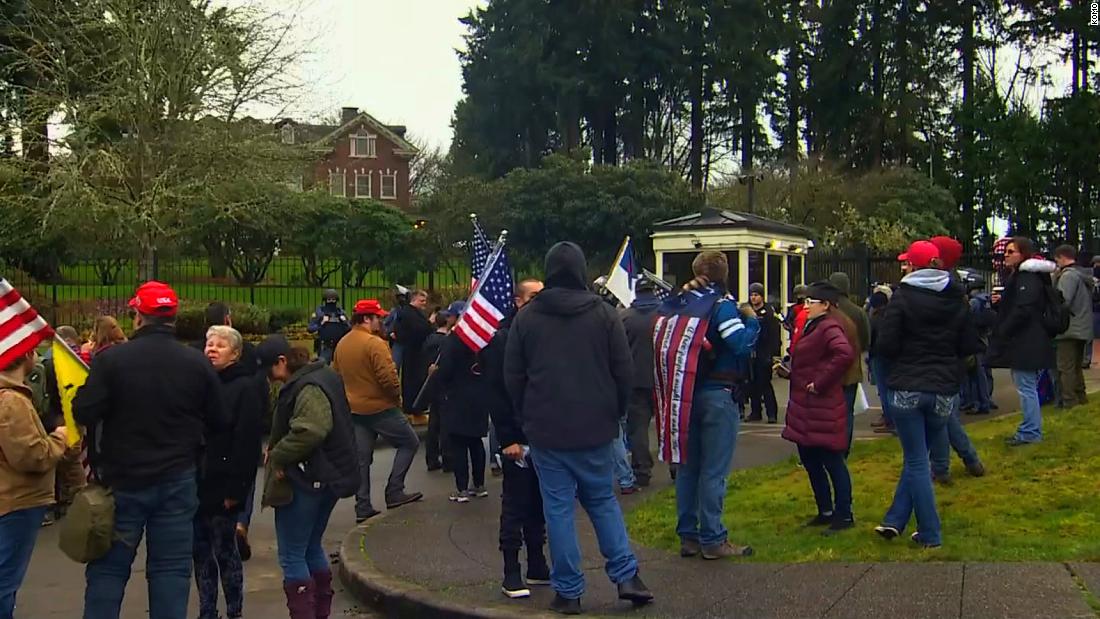Pro-Trump protesters enter the grounds of the Washington governor’s mansion as protesters gather across the country