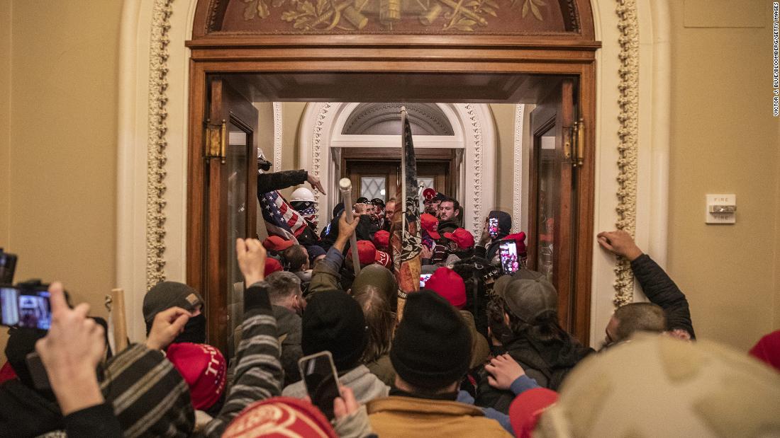 Rioters walk through the Capitol after breaching barricades to the building.