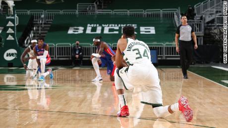 Players from the Bucks and Pistons kneel shortly after the start of an NBA game Wednesday.