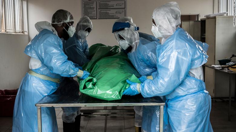 Members of the Saaberie Chishty Burial Society prepare the body of a person who died from COVID-19 at a Johannesburg cemetary Saturday Dec. 26, 2020. South Africa&#39;s health minister has announced an &quot;alarming rate of spread&quot; in the country. 