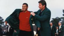 Woods puts on tthe Green Jacket with the help of Nick Faldo at the 1997 Masters presentation ceremony.