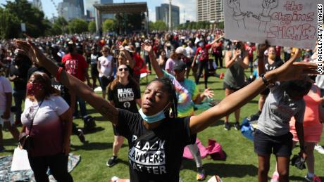 People pray together during a Juneteenth event at Centennial Olympic Park in Atlanta on June 19, 2020.