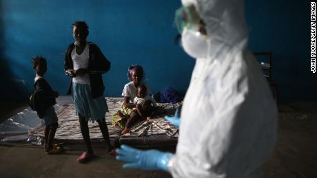 A Liberian health worker speaks with families in a classroom being used as an Ebola isolation ward on August 15, 2014 in Monrovia, Liberia.