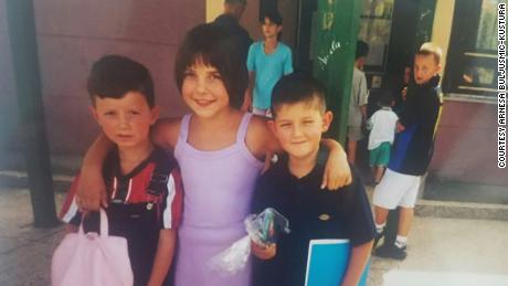 Arnesa Buljusmic-Kustura, center, is pictured with her younger brother and a neighbor on her first day of school after the war ended.