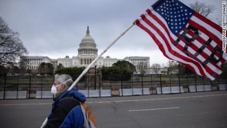 A protester walks by as the American flag flies at half-staff at the US Capitol on January 8, 2021, in Washington.