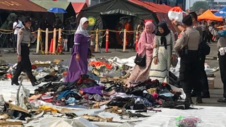 Children&#39;s shoes, lined up on a white tarp in the port, as relatives search for items belonging to their loved ones after the October 29, 2018 Lion Air Flight 610 crash.  
