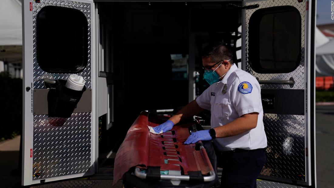 An emergency medical technician disinfects a gurney after transporting a Covid-19 patient in Orange, California.