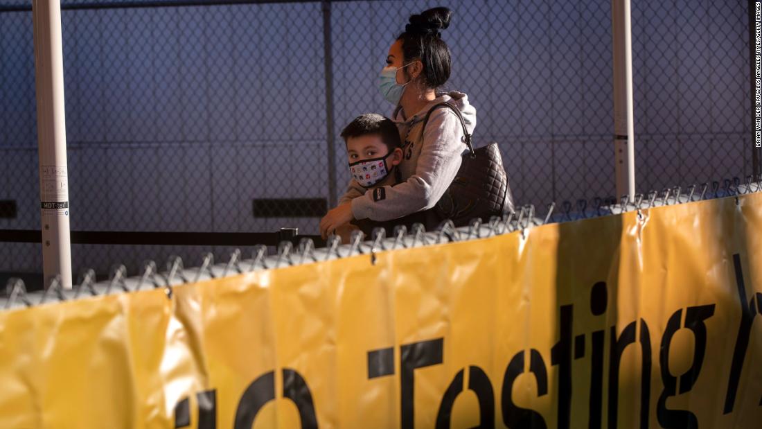 Hawaii-bound travelers Vanna Truong and her 6-year-old son, Frey Das, wait in line for a Covid-19 test in Los Angeles on December 31. A lab is located across Terminal 6 at Los Angeles International Airport, allowing Covid-19 tests to be administered and processed with results in three to five hours.