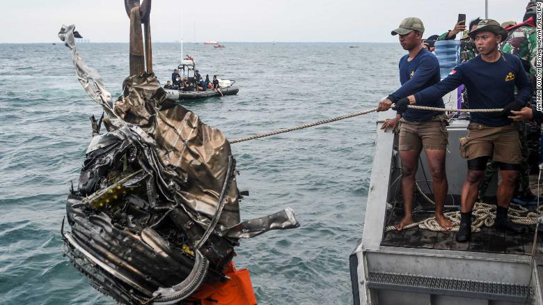 Members of the Indonesian Navy retrieve a piece of debris while searching for the remains of Sriwijaya Air Flight 182 on Monday, January 11.