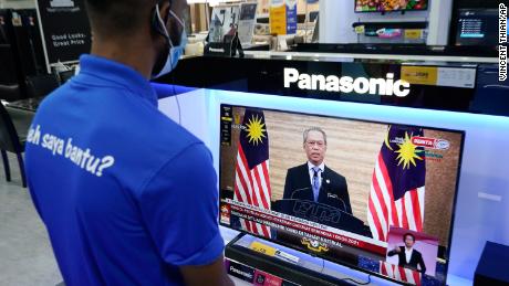 An electronic shop worker watches a live broadcast of Malaysian Prime Minister Muhyiddin Yassin in Kuala Lumpur, Malaysia on January 12.