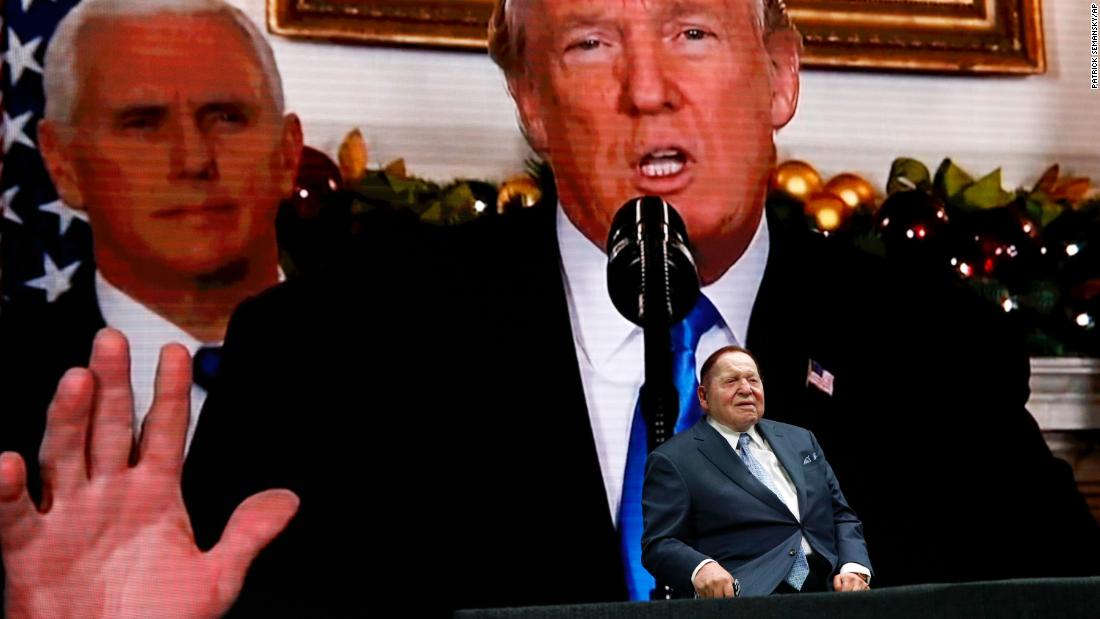 Adelson sits on stage as a video screen depicts Trump and Vice President Mike Pence at the Israeli American Council National Summit in 2019.