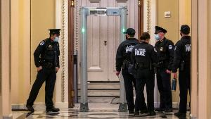 U.S. Capitol Police survey the corridor around the House of Representatives chamber after enhanced security protocols were enacted, including metal detectors for lawmakers, after a mob loyal to President Donald Trump stormed the Capitol, in Washington, Tuesday, Jan. 12, 2021. (AP Photo/J. Scott Applewhite)