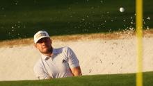 In the first round of the Masters at Augusta Hatton plays a shot out of a bunker. 