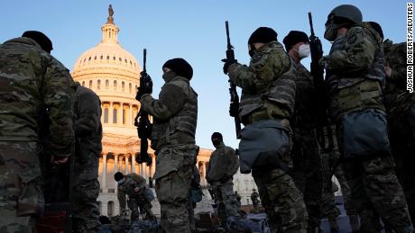 Members of the National Guard are given weapons before Democrats begin debating one article of impeachment against U.S. President Donald Trump at the U.S. Capitol, in Washington, U.S., January 13, 2021. REUTERS/Joshua Roberts