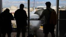 Passengers look out at American Airlines flight 718, a Boeing 737 Max, parked at its gate at Miami International Airport as people load for the flight to New York on December 29, 2020 in Miami, Florida. The Boeing 737 Max flew its first commercial flight since the aircraft was allowed to return to service nearly two years after being grounded worldwide following a pair of separate crashes. (Photo by Joe Raedle/Getty Images)