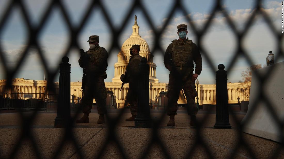 Members of the New York National Guard stand guard along the fence that surrounds the Capitol.