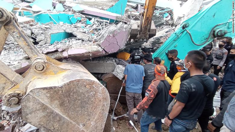 Rescuers search for survivors at a collapsed building in Mamuju city in Indonesia.