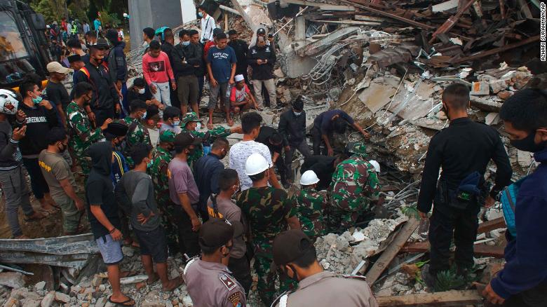 Rescuers search for survivors under a government building that collapsed during an earthquake in Mamuju, West Sulawesi, Indonesia, on Friday, January 15.