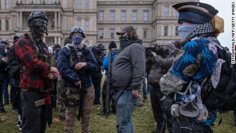 Members of the Michigan Boogaloo Bois an anti-government group stand with their long guns near the Capitol Building in Lansing, Michigan on January 17, 2021, during a nationwide protest called by anti-government and far-right groups supporting US President Donald Trump and his claim of electoral fraud in the November 3 presidential election. - The FBI warned authorities in all 50 states to prepare for armed protests at state capitals in the days leading up to the January 20 presidential inauguration of President-elect Joe Biden. (Photo by SETH HERALD / AFP) (Photo by SETH HERALD/AFP via Getty Images)