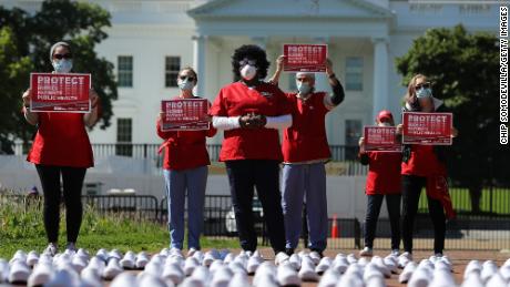 Members of the National Nurses United stand in protest across from the White House, seeking workplaces protections. The empty shoes represent nurses that they say have died from Covid-19. 
