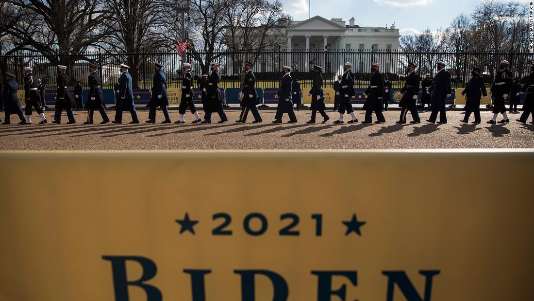 Members of the military walk past the White House during Biden&#39;s abbreviated parade.