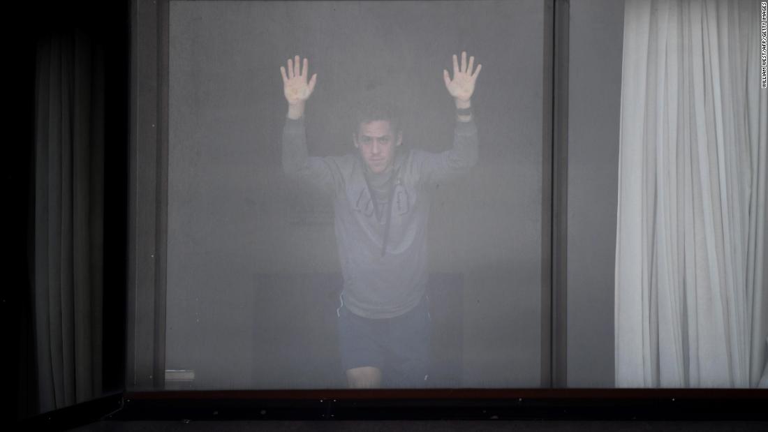 A tennis player waits for a training session from his hotel in Melbourne on January 19. Dozens of players had to quarantine in hotels ahead of the Australian Open.