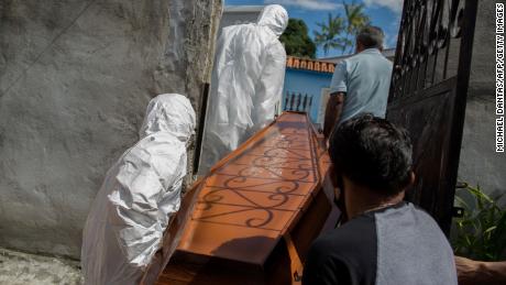 City workers remove the body of Adamor Mendonca Maciel, 75, from his home in Manaus, Brazil on January 16, 2021 after his death from Covid-19.
