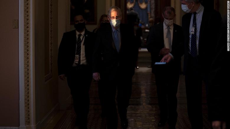 Senate Minority Leader Mitch McConnell, center, wears a protective mask while walking to his office from the Senate Chamber at the U.S. Capitol in Washington, D.C., U.S., on Thursday, Jan. 21, 2021.