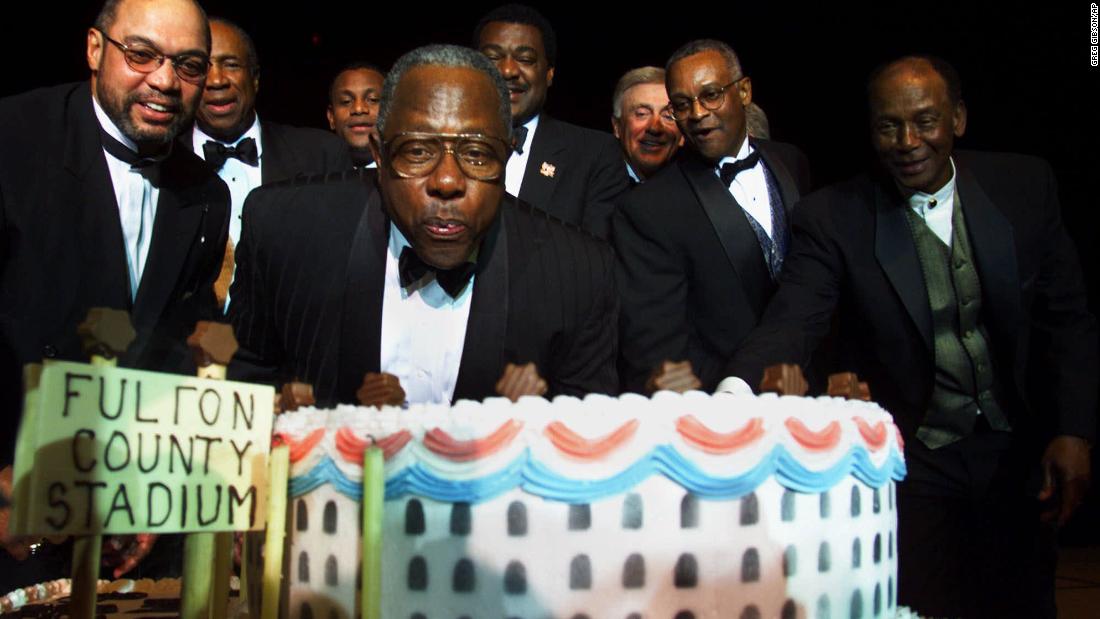 Aaron blows out candles for his 65th birthday in 1999. Behind him are many baseball greats: from left, Reggie Jackson, Frank Robinson, Sammy Sosa, Don Baylor, Phil Niekro, Sonny Jackson and Ernie Banks.