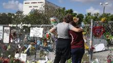 Margarita Lasalle, right, and Joellen Berman look at the memorial outside Marjory Stoneman Douglas High School as teachers and staff return to school February 23, 2018, for the first time since the mass shooting.