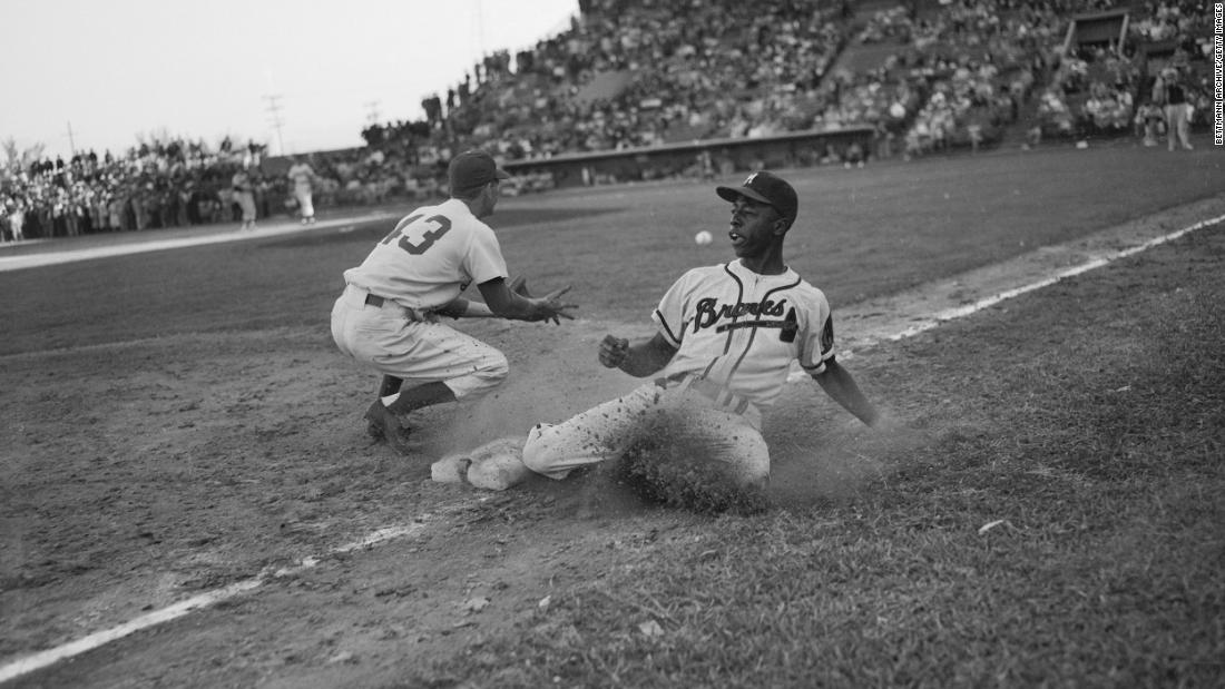 Aaron slides back to third base during an exhibition game in 1954. Aaron&#39;s career began in the Negro Leagues before he broke into the majors with the Milwaukee Braves.