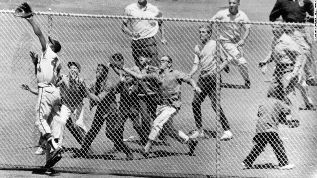 Fans rush to the fence at San Francisco&#39;s Candlestick Park as Aaron reaches for a catch in 1961. Aaron won three Golden Glove awards for his fielding during his career.