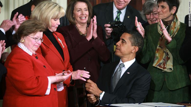 President Barack Obama hands Lilly Ledbetter a pen after signing the Lilly Ledbetter Fair Pay Act during an event in the East Room of the White House January 29, 2009 in Washington, DC. 