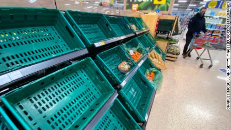 A supermarket customer looks at the near empty shelves in Tescos on January 14, 2021 in Belfast, Northern Ireland. 