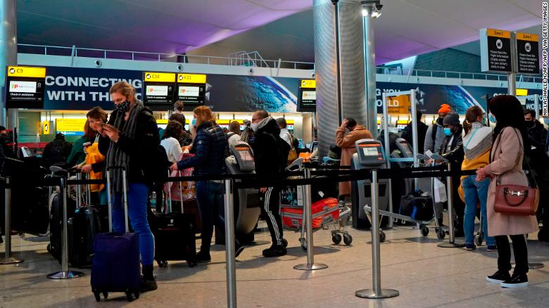 Passengers queue at a check-in desk at Heathrow Airport in London on December 21.