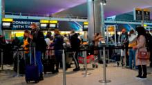 Passengers queue at a check-in desk at Heathrow Airport in London on December 21.