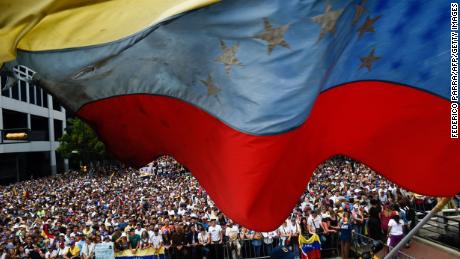 A Venezuelan national flag flutters during a mass opposition rally against President Nicolas Maduro in which Venezuela&#39;s National Assembly head Juan Guaido (out of frame) declared himself the country&#39;s &quot;acting president&quot;, on the anniversary of a 1958 uprising that overthrew a military dictatorship, in Caracas on January 23, 2019. 