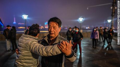 Elderly couples dance along the Yangtze River that cuts through the heart of Wuhan.